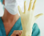 Una enfermera colocándose un guante plástico