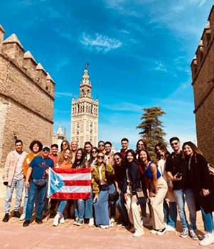 Estudiantes parados frente a una torre en Sevilla